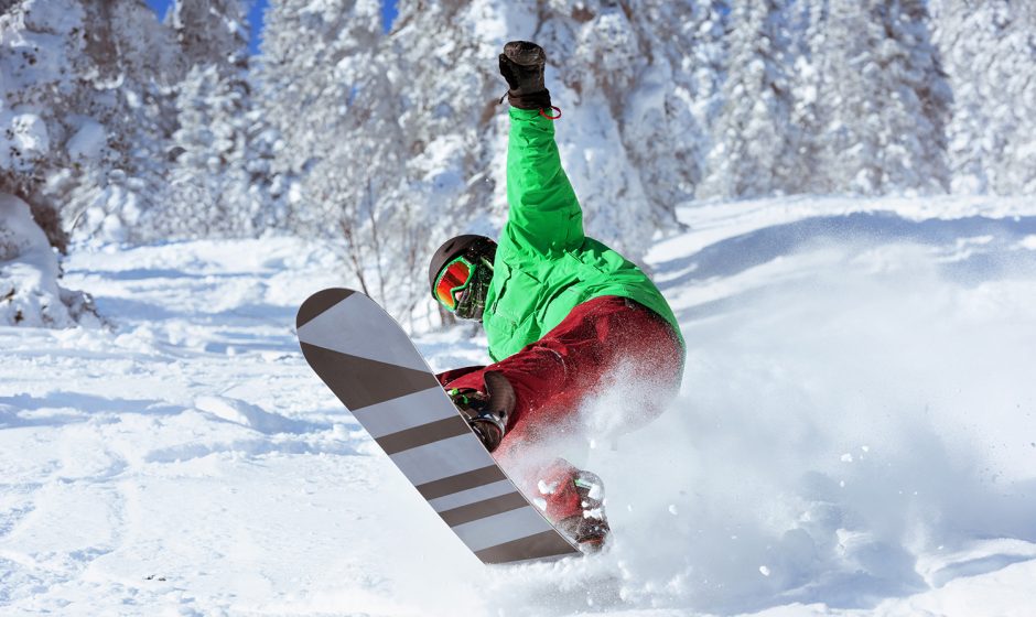 Snowboarder jumps in forest freeride in powder. Sheregesh ski resort